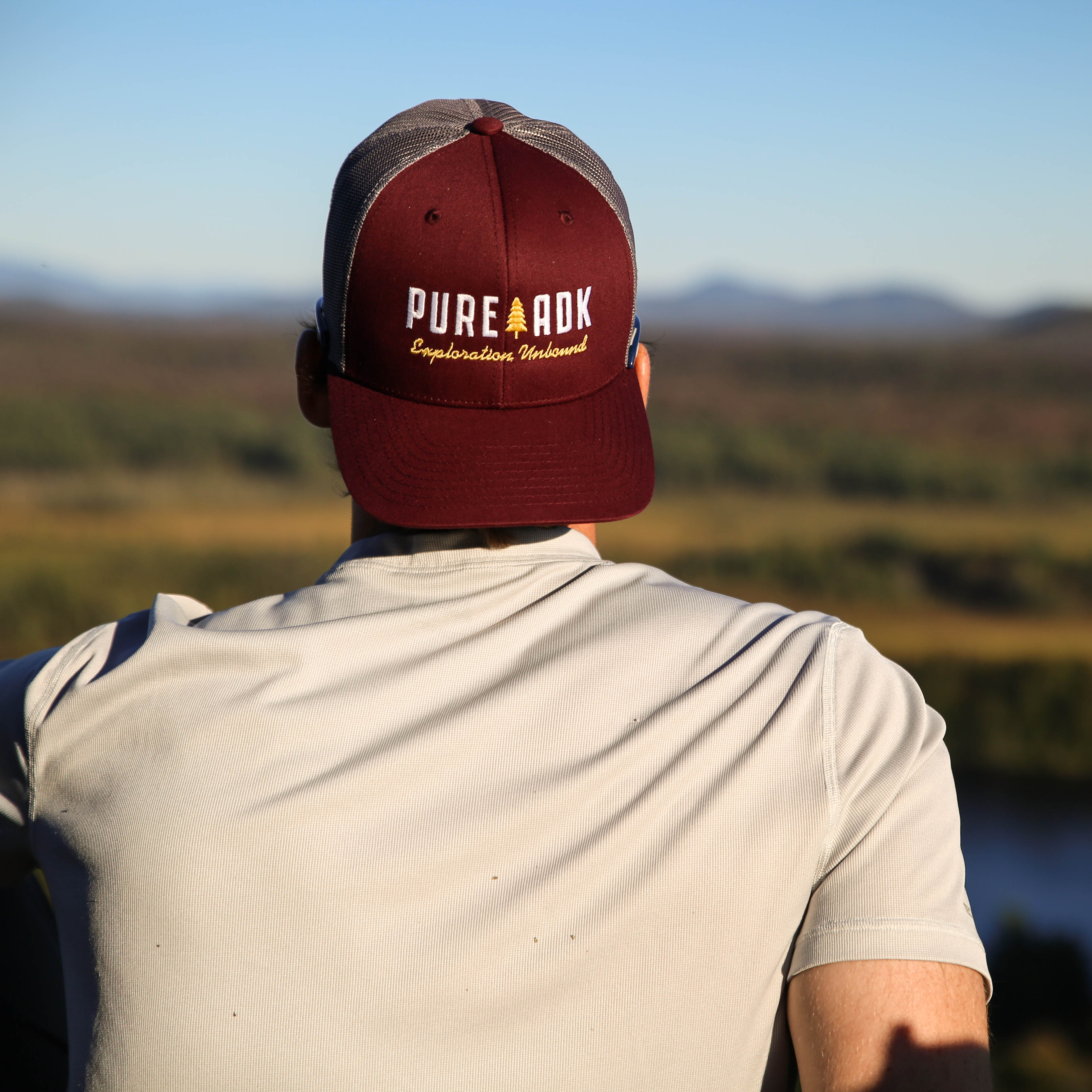 PureADK hat overlooking the mountains
